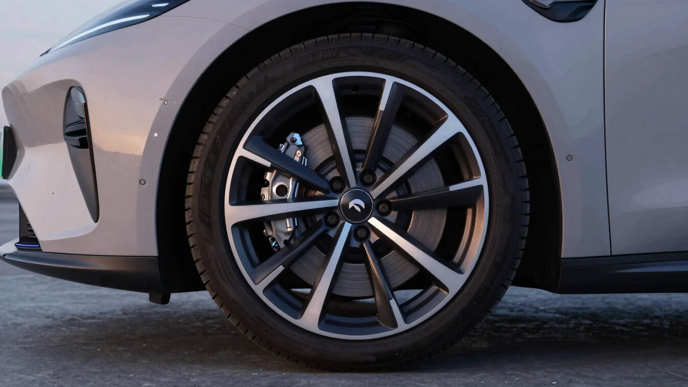 Close-up of high-performance electric car wheel and brake system with subtle blue accent lighting, studio crisp